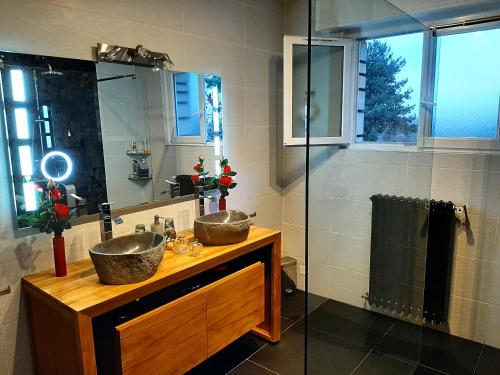 a bathroom with two sinks and a shower at Villa avec piscine proche Disneyland et Paris in Saint-Thibault-des-Vignes