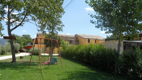 a swing set in the grass in a yard at Agriturismo Stovali Da Lustrinu in Protte