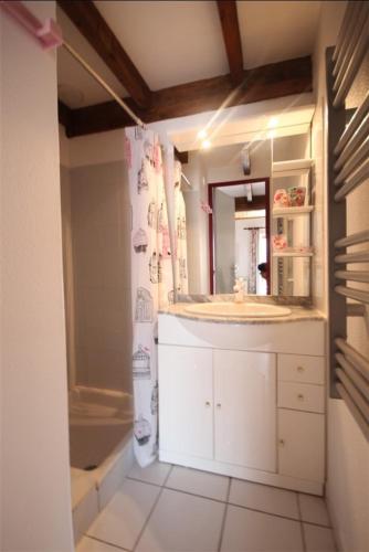 une salle de bain avec un lavabo, un miroir et une baignoire dans l'établissement villa 5 couchages terrasse ombragée parking dans résidence sécurisée avec piscine commune à 400m de la mer LRJP65, à Portiragnes