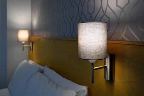 a lamp on a wall next to a bed at The Corner House Hotel in Annan