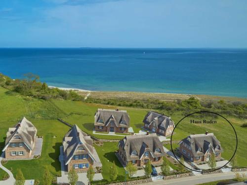 an aerial view of a house with the ocean in the background at Strandhaus Ruden F661 Haus 5 mit Meerblick in Lobbe