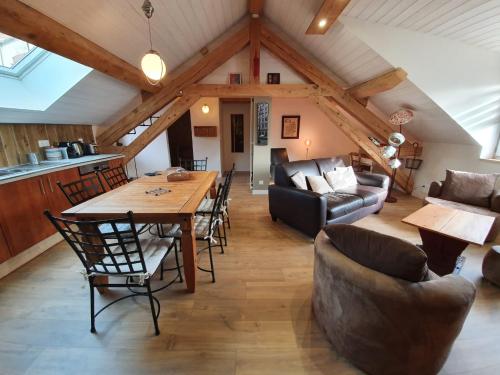 un salon avec une table et des chaises en bois dans l'établissement La fontaine des amis, à Gap