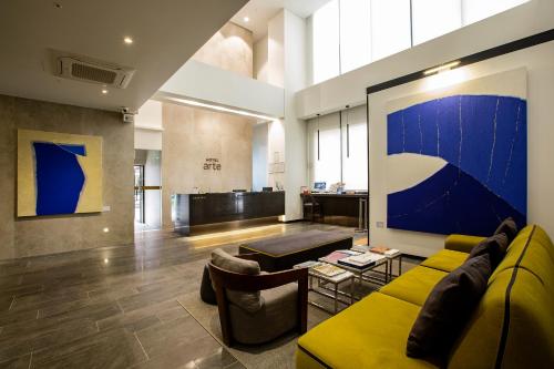 a living room with a yellow couch and a table at Hotel Arte in Suwon