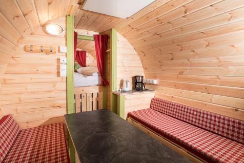 una habitación con un banco y una cama en una cabaña en Remsfass, en Schwäbisch Gmünd