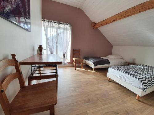 a bedroom with a bed and a desk and a window at La fontaine des amis in Gap