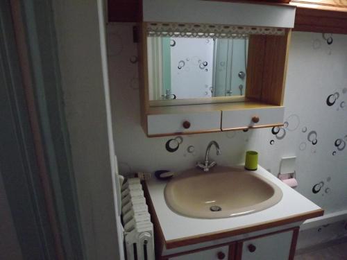 ein Bad mit einem Waschbecken und einem Spiegel in der Unterkunft Chez Lili in Izé