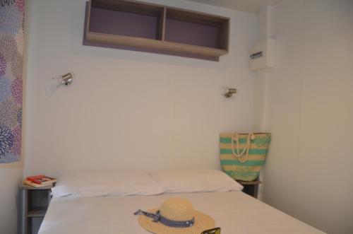 un cappello seduto su un letto in una stanza di Happy Camp mobile homes in Camping Sènia Cala Canyelles a Lloret de Mar