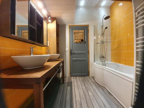 a bathroom with two sinks and a tub and a shower at La fontaine des amis in Gap