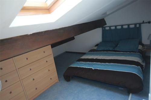 - une chambre mansardée avec un lit et une commode dans l'établissement villa 3 chambres 6 couchages, cuisine climatisée, petite terrasse, résidence sécurisée piscine commune 400m de la mer LRJP50, à Portiragnes