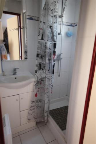 une salle de bain avec un lavabo et un rideau de douche dans l'établissement villa 3 chambres 6 couchages, cuisine climatisée, petite terrasse, résidence sécurisée piscine commune 400m de la mer LRJP50, à Portiragnes