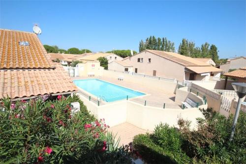- une vue sur la piscine dans une maison dans l'établissement villa 3 chambres 6 couchages, cuisine climatisée, petite terrasse, résidence sécurisée piscine commune 400m de la mer LRJP50, à Portiragnes