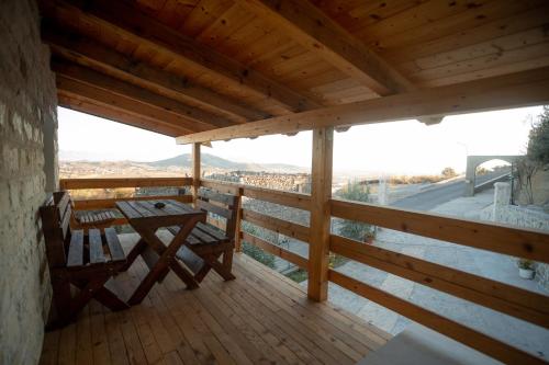 a wooden balcony with a table and a view at Hotel Grandpa's House in Shkodër