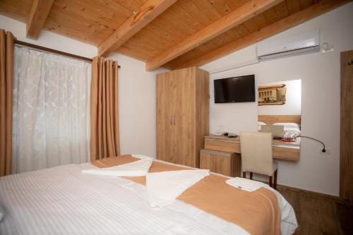a bedroom with a bed and a desk with a computer at Hotel Grandpa's House in Shkodër