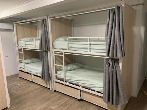 2 Etagenbetten in einem Zimmer mit Holzböden in der Unterkunft Mumma's Hostel Surfers Paradise in Gold Coast