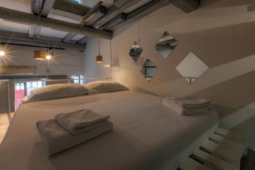 uma grande cama branca num quarto com duas toalhas em Casa Cerami em Catânia