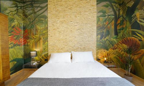 La Tigre Appartamento Con Terrazza In Centro في كالياري: غرفة نوم بسرير مع لوحة على الحائط