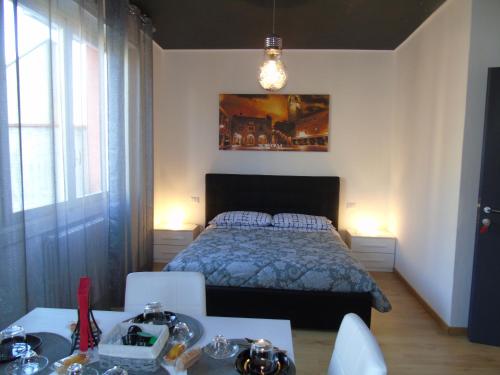 Azzano San PaoloにあるCasa Leonardo Airportのベッドルーム1室(ベッド1台、テーブル2台、椅子付)