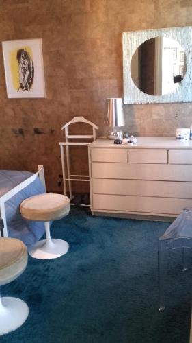 a room with a dresser and a stool and a mirror at Gioiello sul mare in Ospedaletti