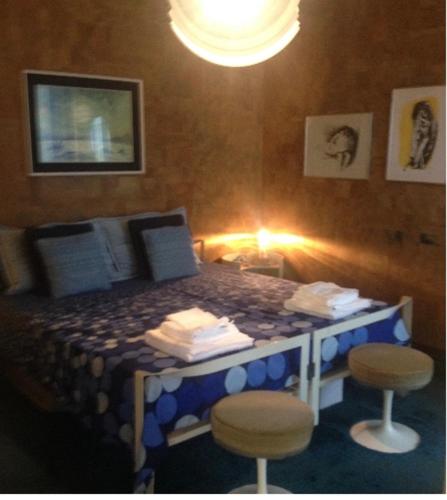 a bedroom with a bed with stools in it at Gioiello sul mare in Ospedaletti