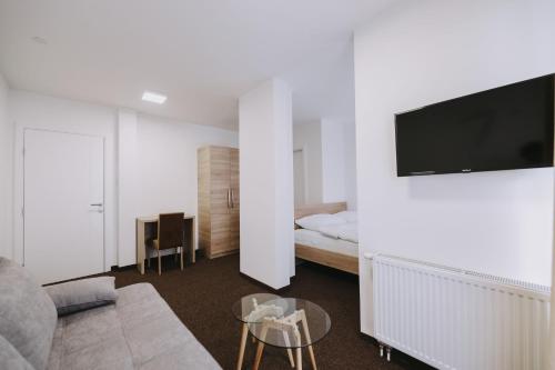 a living room with a couch and a tv on a wall at Hotel Tanja in Banja Luka