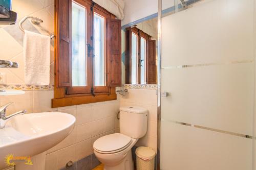 a bathroom with a toilet and a sink at Estudios Bahia de la Plata in Zahara de los Atunes