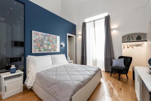 1 dormitorio con cama y pared azul en I Colori della Puglia Rooms, en Trani