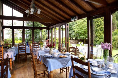 uma sala de jantar com mesas, cadeiras e janelas em Toghill House Farm em Wick