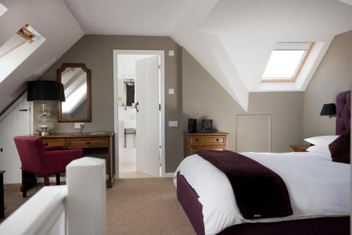 a bedroom with a bed and a desk and a mirror at Crouchers Hotel in Chichester