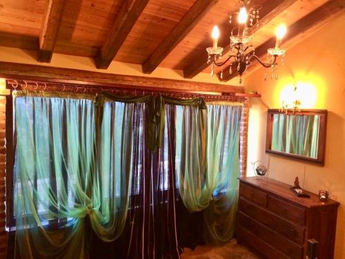 een kamer met gordijnen, een dressoir en een kroonluchter bij Ermones Emerald Villa in Vátos