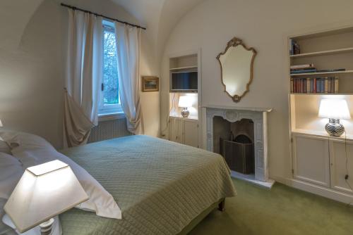 a bedroom with a bed and a fireplace at Dimora 1690 in Savigliano
