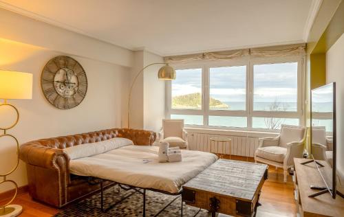 サン・セバスティアンにあるMaskortxo - Basque Stayのソファと大きな窓のあるリビングルーム