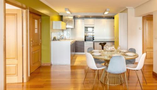 サン・セバスティアンにあるMaskortxo - Basque Stayのテーブルと椅子のあるキッチンとダイニングルーム