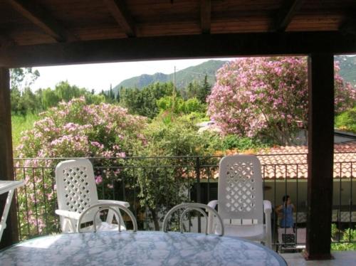 una mesa y sillas en un balcón con flores en Deiana's Apartment - Cardedu Beachside, en Cardedu