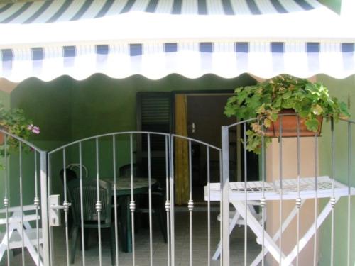 patio con tavolo, tavolo e tenda da sole di Deiana's Apartment - Cardedu Beachside a Cardedu