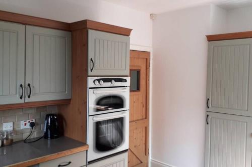 a kitchen with a stove and a washer and oven at Peggys Escape in Ballycastle
