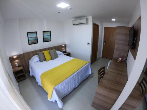 a bedroom with a bed with a yellow blanket at Villa d'Oro Hotel in Recife