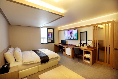 テグにあるHotel Two Heartのベッドとパソコン付きの机がある寝室