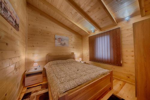 sypialnia z łóżkiem w drewnianym domku w obiekcie Rejan Lux w Ulcinju