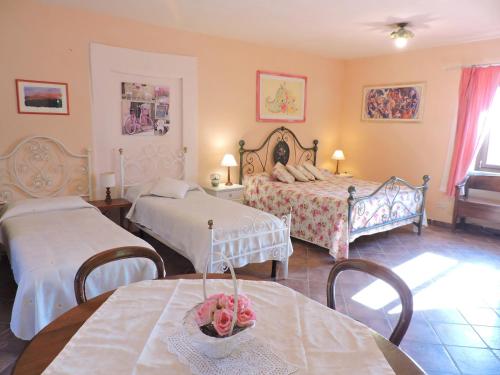 a bedroom with two beds and a table with flowers on it at Casale Fedele Family Relax B&B Vicino al Borgo in Ronciglione