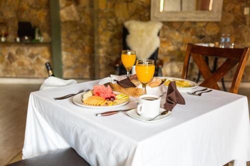 a table with a plate of food and two glasses of orange juice at Hotel Boutique Matea in Ixtapan de la Sal