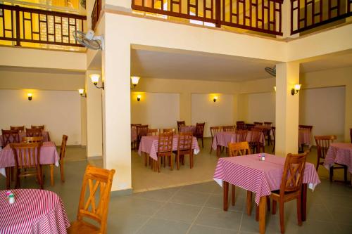 un restaurante con mesas y sillas con mantel rosa en Tropic Garden Hotel, en Banjul