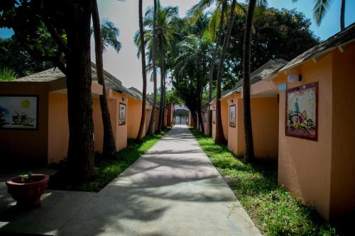 a long path between buildings with palm trees at Tropic Garden Hotel in Bathurst