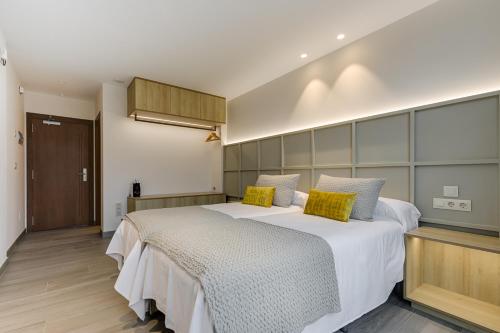a hotel room with two beds and a mirror at A Casa do Latoneiro in Caldas de Reis
