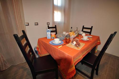a dining room table with a orange table cloth at B&B Libellula in Iglesias