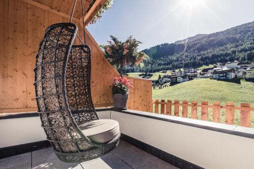 a chair on a balcony with a view of a mountain at Leni Mountain Appartements in Sölden