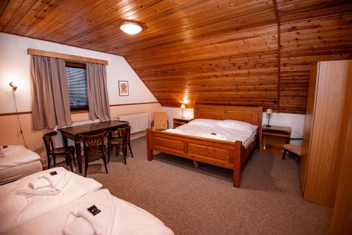 a room with two beds and a table in a cabin at Penzion Čert in Horní Maršov