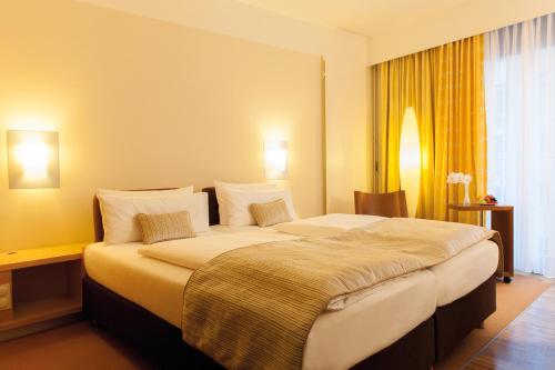 a hotel room with a large bed with pillows at centrovital Hotel Berlin in Berlin