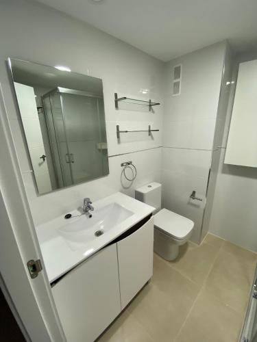 a white bathroom with a sink and a toilet at MAR BLAU - FINCAS ARENA in Benidorm