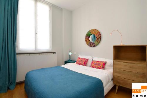 a bedroom with a blue and white bed and windows at 202117 - Appartement 6 personnes à Paris in Paris