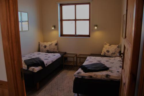 Habitación pequeña con 2 camas y ventana en Egilsstaðir 1 Guesthouse en Villingaholt